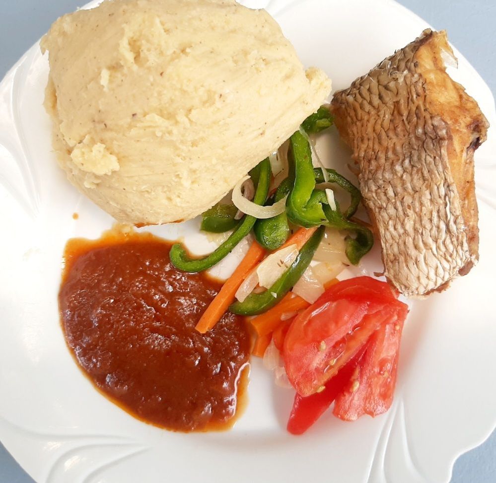 Caption: A local African dish(Ghanaian) called Kenkey. Green pepper,tomatoes and a little spicy sauce with fried fish on the side