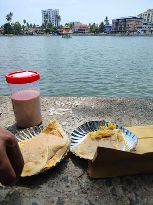 trying boli and payasam in front of the pond