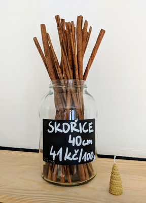 A glass jar of loose sticks of cinnamon, sold by weight for 41 Czech Crowns per 100g