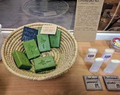 Bars of olive soap, package-free in a wicker bowl; deodorant in reusable plastic holders