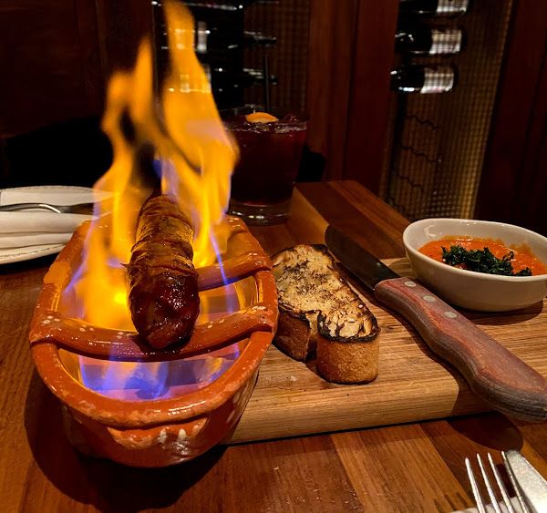 Linguiça assada on fire at Oporto Fooding House & Wine in Houston