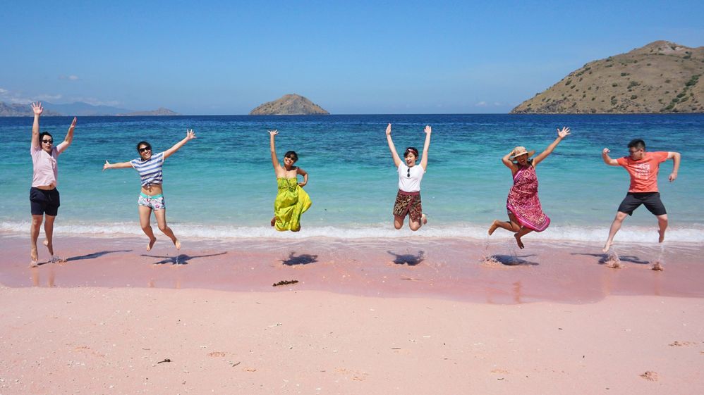 A photo of me and my friends jumping together on the Pink Beach, Komodo Island.